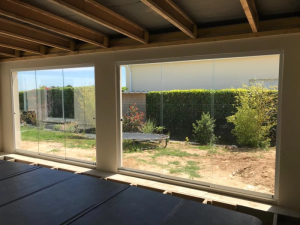 Paroi vitree coulissante sans cadre, vue jardin depuis interieur en travaux