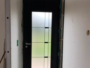 Porte acier anthracite, vitrage dépoli géométrique, placo et mousse bleue autour du cadre