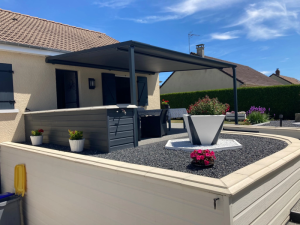 Pergola anthracite adossee, terrasse gravier, palmiers et haie verte