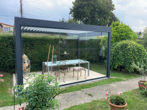 Pergola bioclimatique anthracite, lames blanches, vitrages et table de jardin