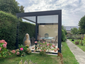 Pergola anthracite vitree, table a manger sous haie et hortensias roses