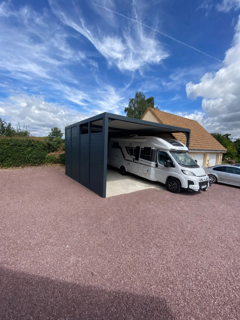 Carport grande hauteur anthracite, camping-car blanc garé sur dalle béton