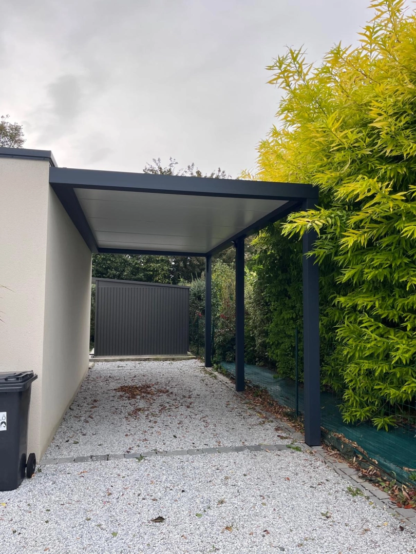 Carport alu anthracite adossé toit blanc, allée gravier et haie bambous