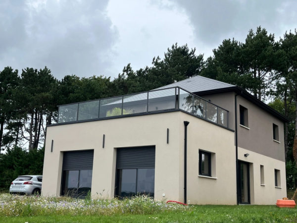 Maison moderne : menuiseries noires, volets roulants et garde-corps verre sur toit-terrasse