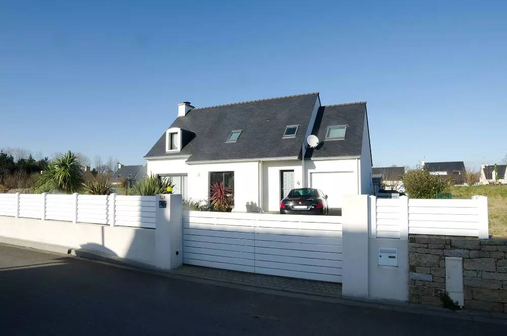 Portail coulissant et clôture lames horizontales blanches, maison blanche, menuiseries sombres