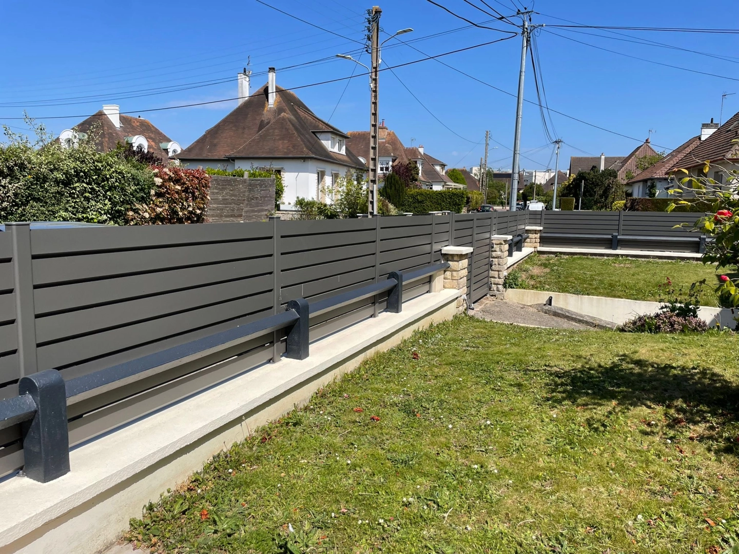 Clôture et portillon anthracite lames horizontales sur muret, pelouse et lotissement
