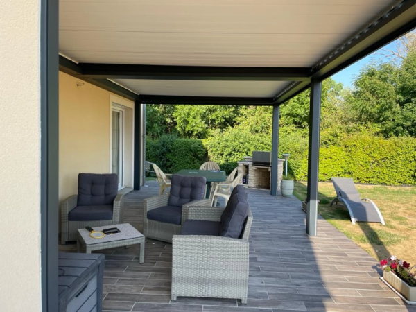 Pergola bioclimatique adossée anthracite, lames blanches, terrasse carrelage effet bois