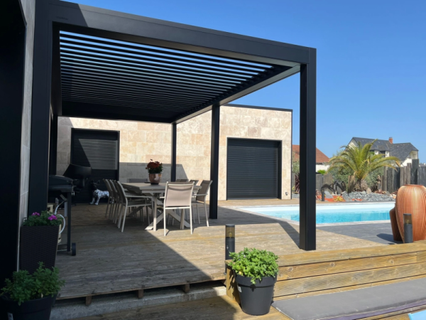Pergola bioclimatique noire, lames orientables, terrasse bois et piscine bleue