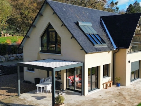 Maison crépi : pergola bioclimatique anthracite, baies alu, lucarnes et volets roulants