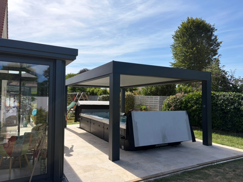 Pergola anthracite toit plat abritant un spa de nage sur terrasse pierre claire