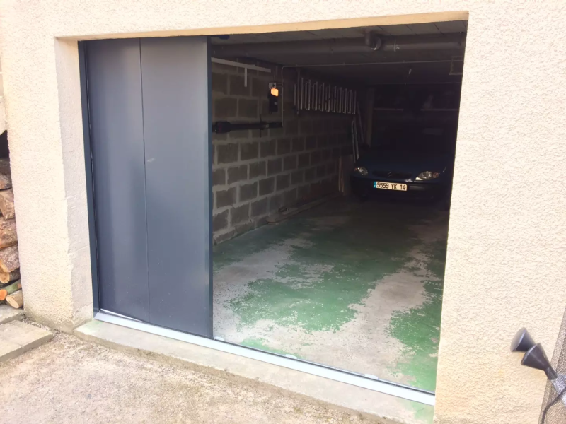 Porte de garage latérale gris anthracite coulissante, rail au sol, intérieur garage béton
