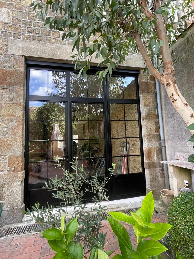 Baie style verrière alu noir, petits bois, trois vantaux, mur pierre