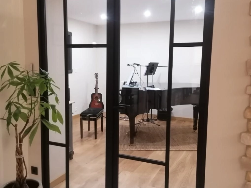 Verrière intérieure alu noir style atelier, portes vitrées, salon piano visible