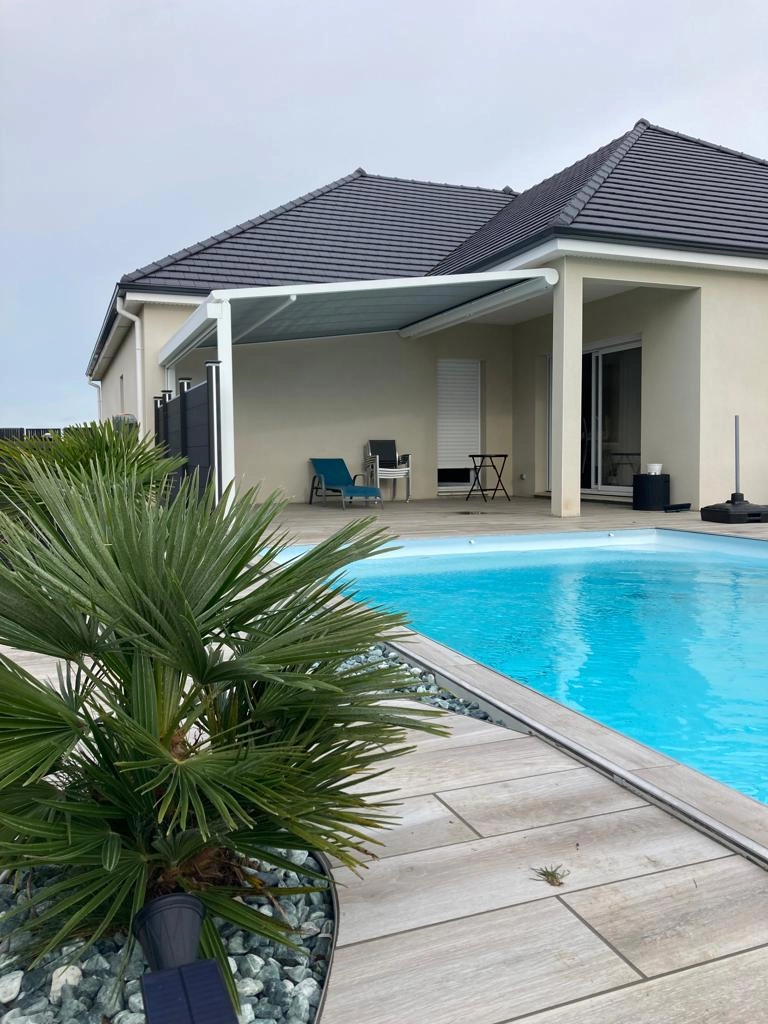 Pergola blanche toile grise rétractable, terrasse carrelée, piscine turquoise