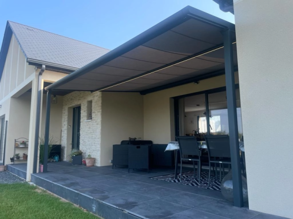 Pergola adossée anthracite, toile grise rétractable, bandeau LED, dalles sombres
