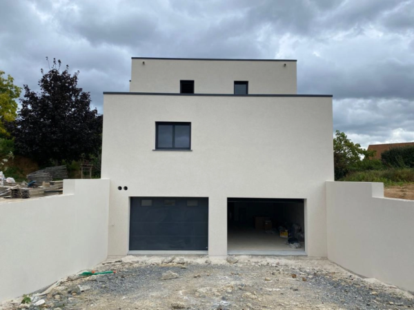 Maison cubique toits plats, enduit crème, menuiseries anthracite, garage sectionnel