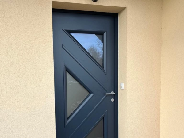 Porte d'entrée anthracite, trois vitrages triangulaires dépolis, enduit beige