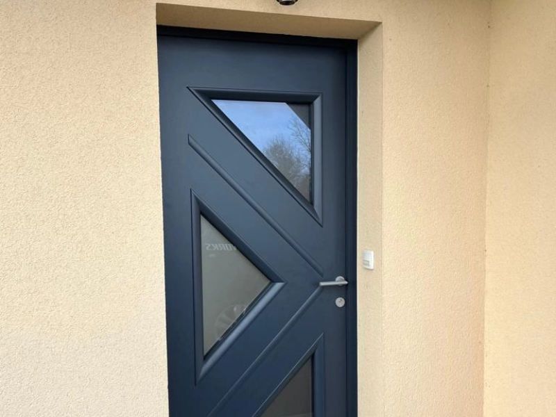 Porte d'entrée anthracite, trois vitrages triangulaires dépolis, enduit beige