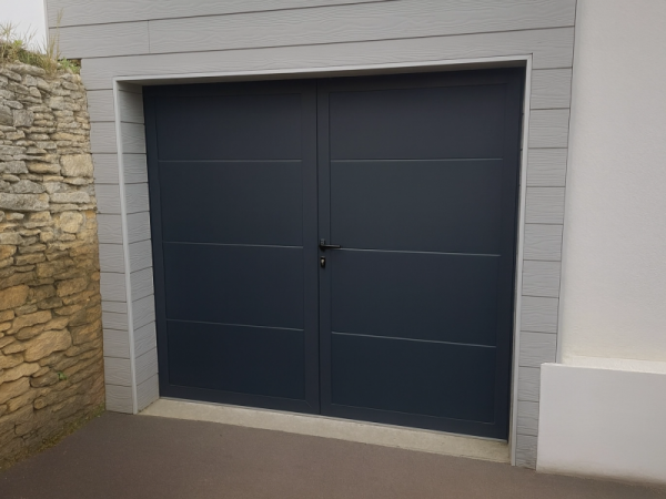 Porte garage battante anthracite deux vantaux rainurés, bardage gris et pierre