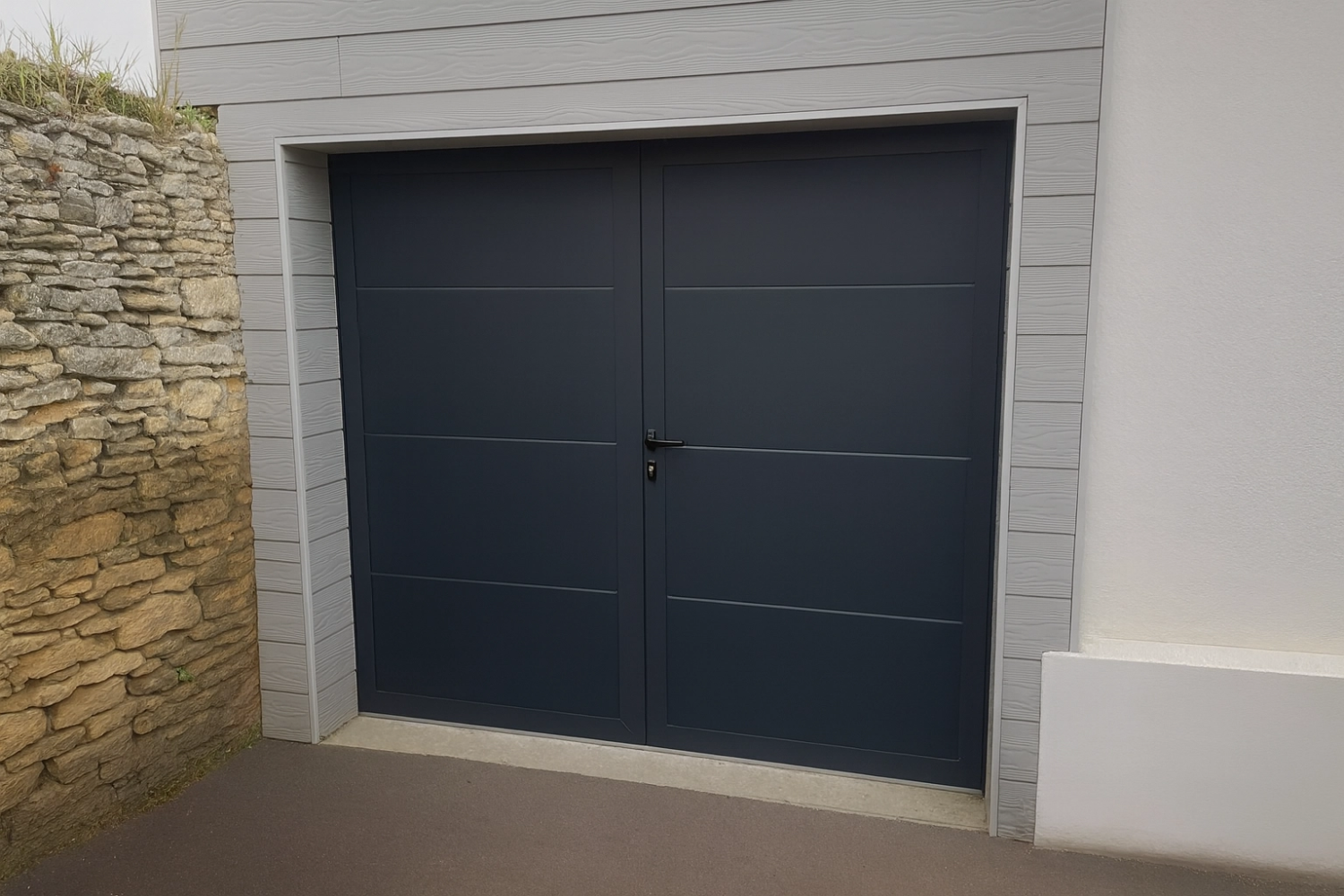 Porte garage battante anthracite deux vantaux rainurés, bardage gris et pierre