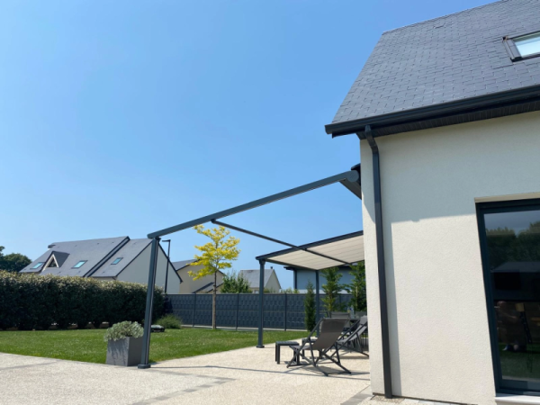 Storgola alu anthracite, toile rétractable crème, terrasse béton désactivé et transats gris