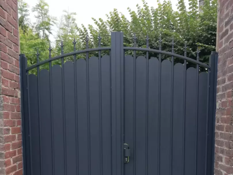 Portail battant alu gris anthracite, lames pleines festonnées et barreaux à lances, piliers briques