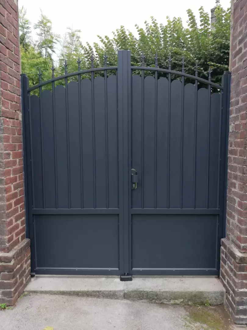 Portail battant alu gris anthracite, lames pleines festonnées et barreaux à lances, piliers briques