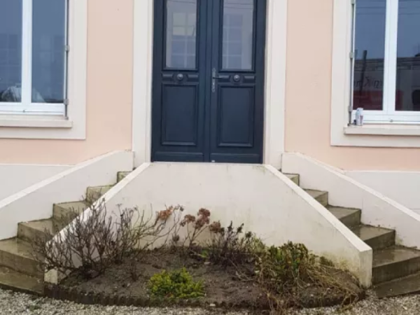 Porte d'entrée double bleu foncé vitrée, fenêtres blanches, façade saumon et marches béton