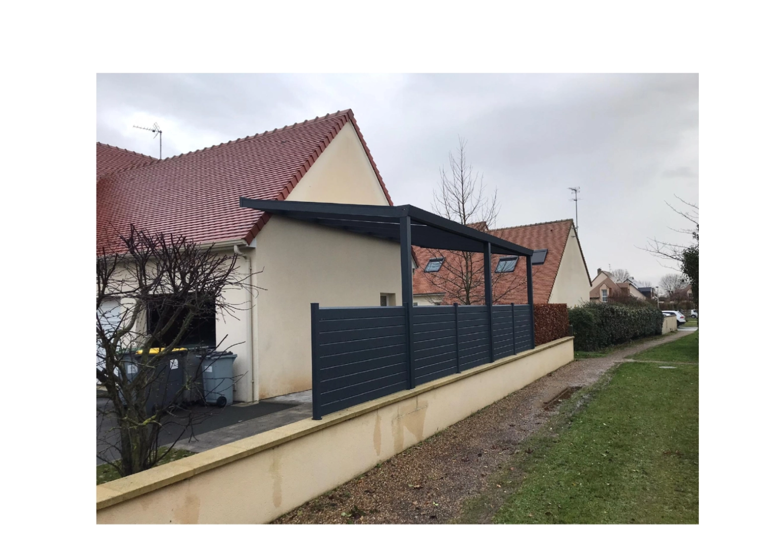 Carport anthracite adossé, toit translucide, claustra lames sur muret, tuiles rouges