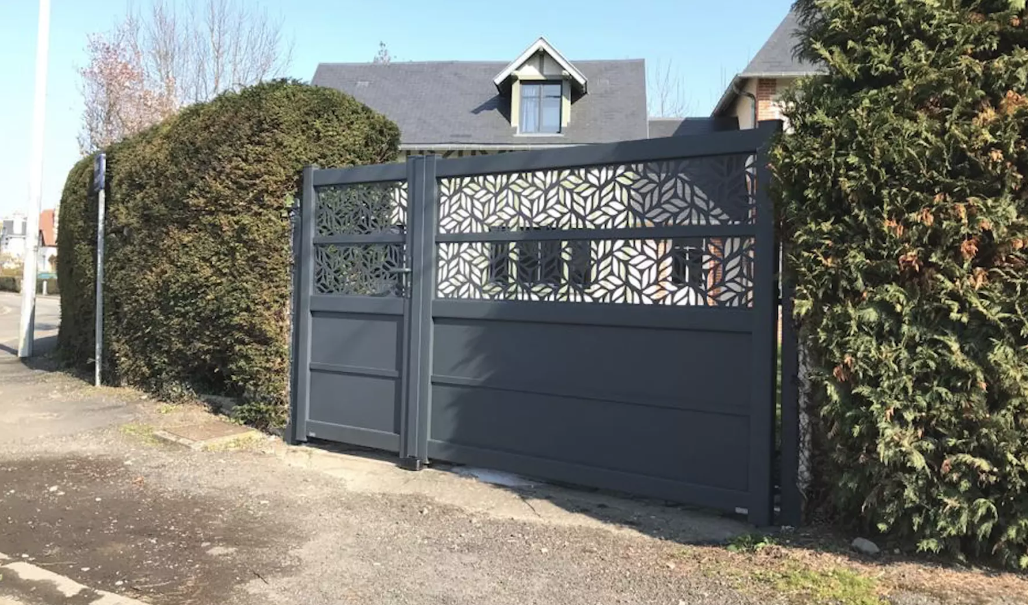 Portail et portillon anthracite, motifs feuilles découpés laser, haies vertes