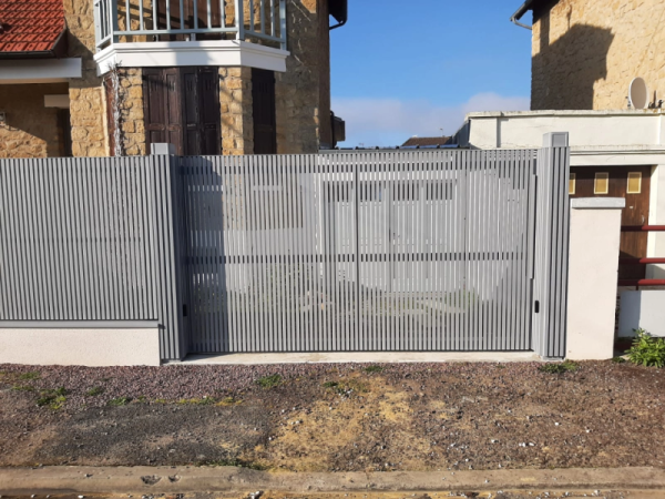 Portail et clôture alu gris clair à lames verticales devant maison en pierre