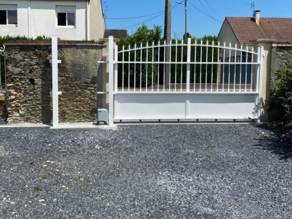 Portail coulissant blanc chapeau de gendarme, barreaudage et motorisation, murets en pierre