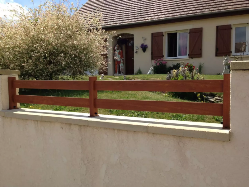 Clôture deux lisses aspect bois marron sur muret enduit beige, maison et volets assortis