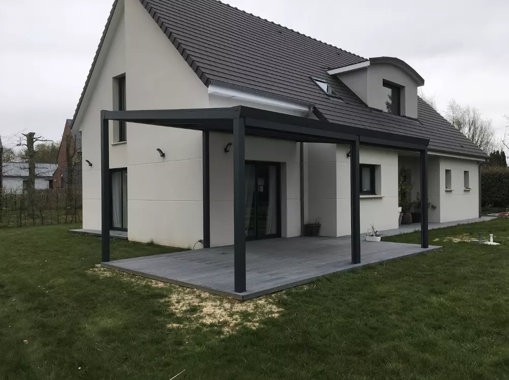 Pergola bioclimatique alu anthracite adossée, grande terrasse composite grise, lucarne ronde
