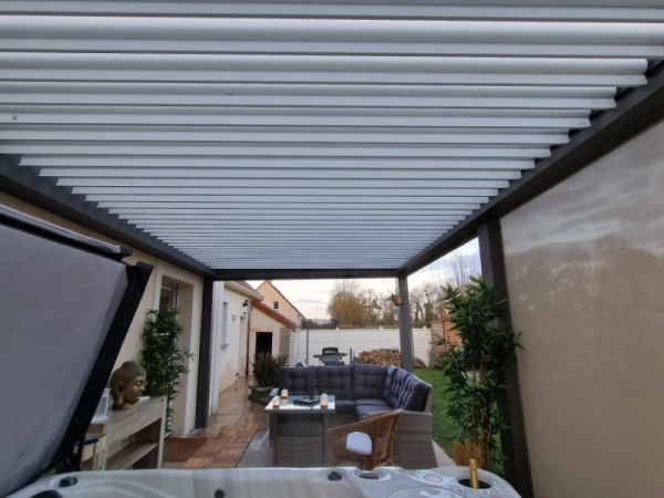 Pergola bioclimatique anthracite, lames blanches, salon et spa sous structure