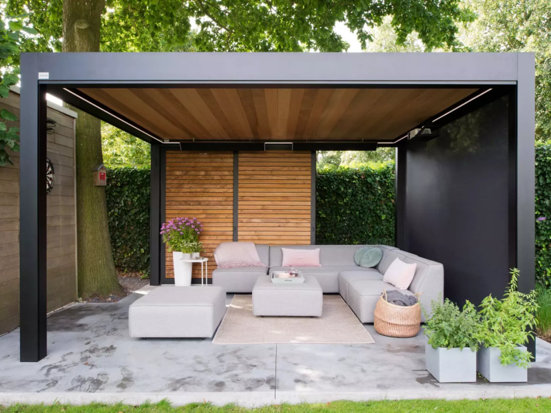 Pergola alu noir, plafond lames bois, claustra horizontal, terrasse béton et salon extérieur