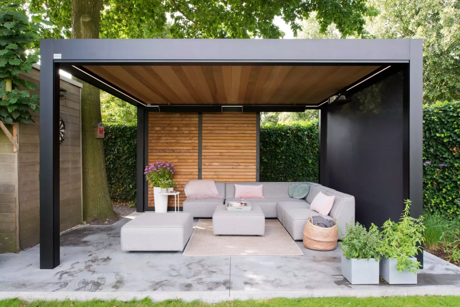 Pergola alu noir, plafond lames bois, claustra horizontal, terrasse béton et salon extérieur