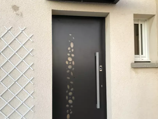 Porte d'entrée alu gris anthracite, motifs vitrés organiques, longue poignée inox, enduit beige