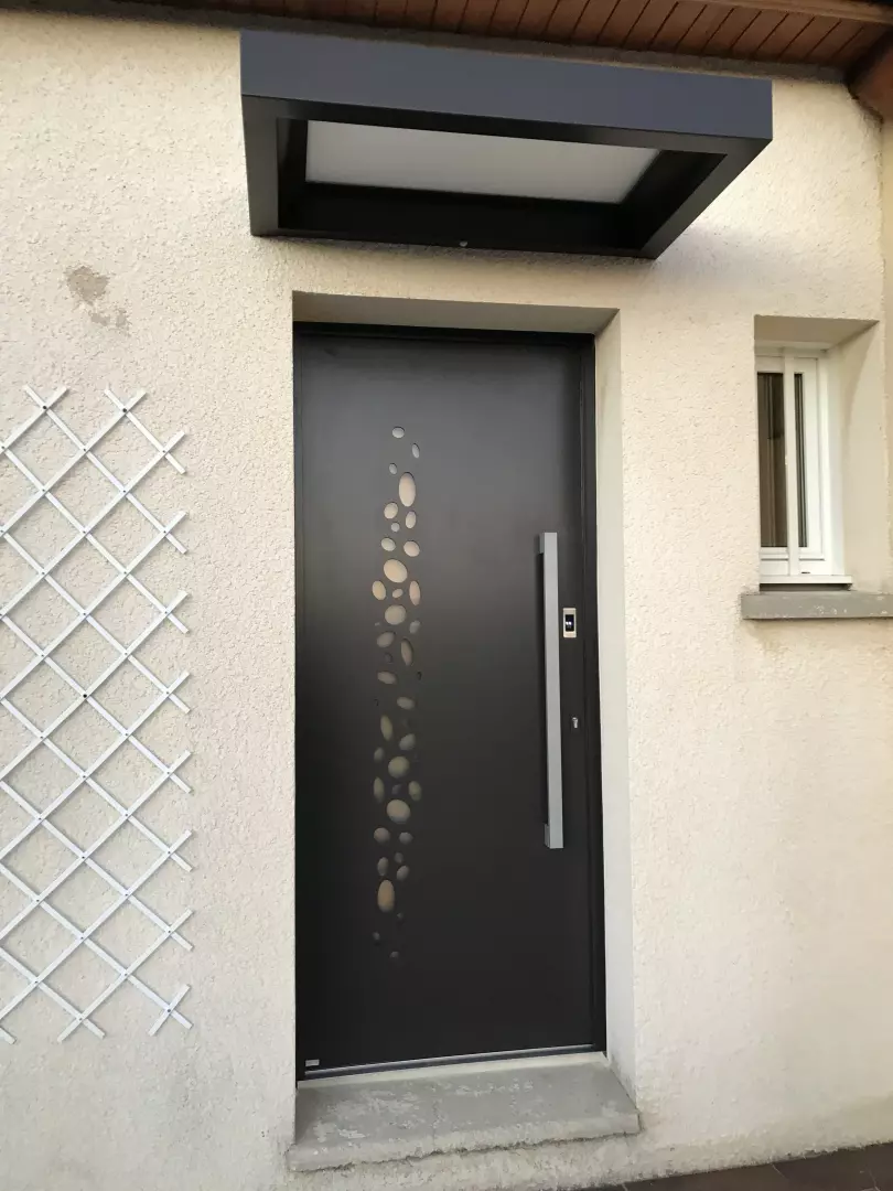 Porte d'entrée alu gris anthracite, motifs vitrés organiques, longue poignée inox, enduit beige