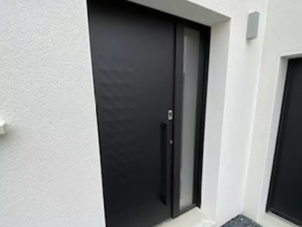Porte d'entrée alu noir mat, imposte dépolie, poignée verticale, encadrement enduit blanc