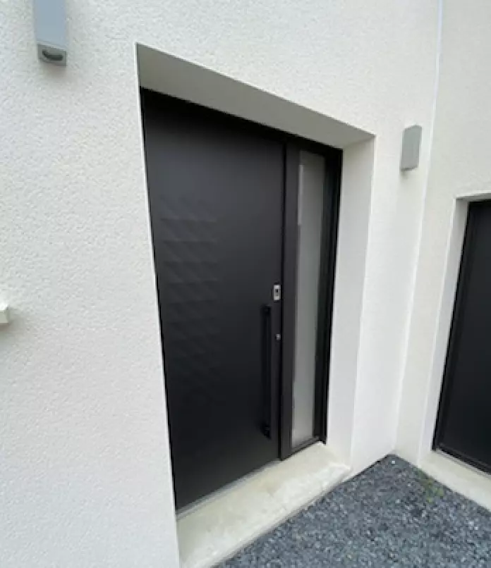 Porte d'entrée alu noir mat, imposte dépolie, poignée verticale, encadrement enduit blanc