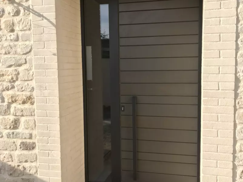 Porte d'entrée gris anthracite lames horizontales, imposte vitrée, encadrement briques claires