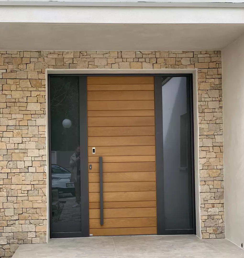 Porte d'entrée lames bois clair, cadre anthracite, impostes vitrées, encadrement pierre naturelle