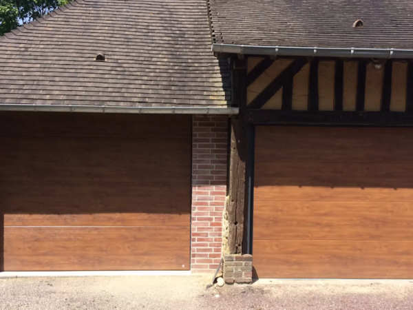 Deux portes sectionnelles aspect bois chêne, façade colombages et pilier briques