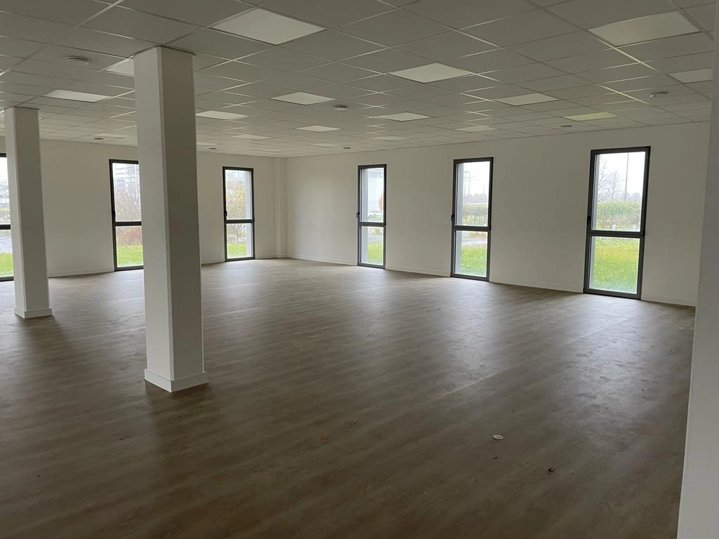 Open space, fenêtres verticales alu anthracite, plafond dalles et sol effet bois