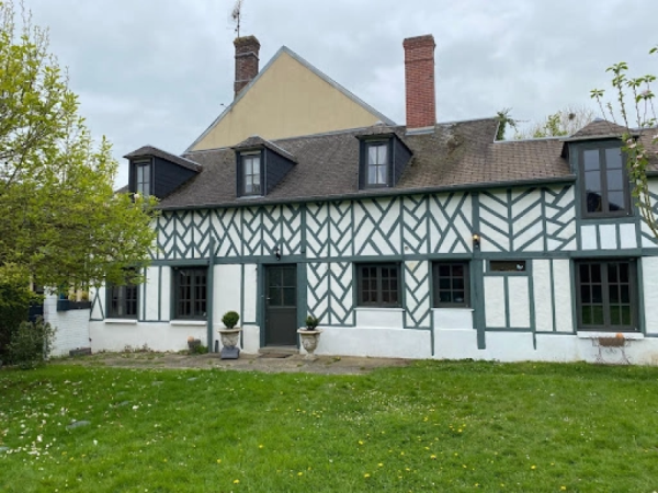 Longère à colombages rénovée, menuiseries gris anthracite et lucarnes