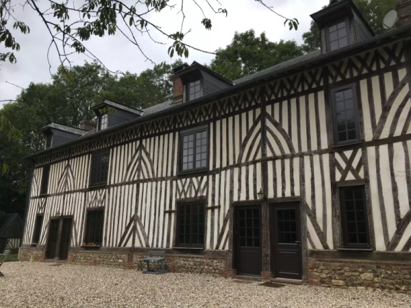 Maison à colombages, fenêtres et portes anthracite à petits carreaux, toiture ardoise et lucarnes