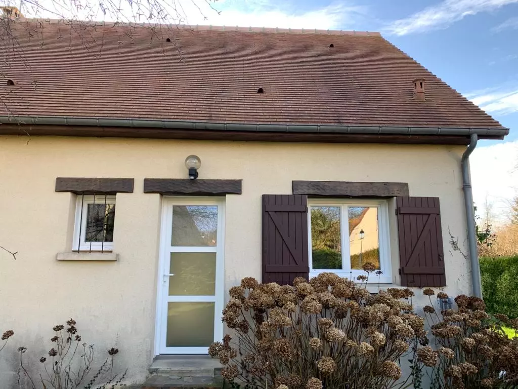 Porte PVC blanche à trois bandeaux vitrés, fenêtres blanches, volets bois marron, façade crème
