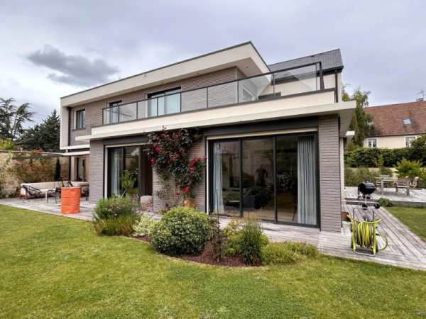 Extension moderne : baies alu anthracite, bardage bois gris, terrasse bois et garde-corps verre
