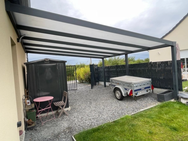 Carport alu anthracite adossé, toiture blanche, gravier, abri de jardin et remorque
